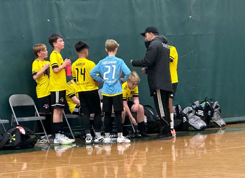Real Boston FC futsal players receiving coaching during a match